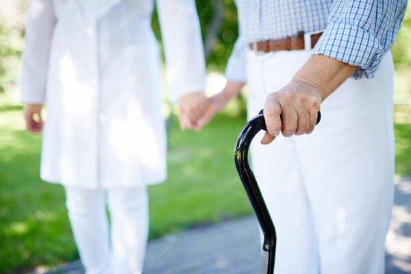 nurse walking with elderly man