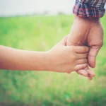 child holding parent's hand