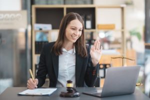 Asian female lawyer chatting online with client on laptop discussing details of lawsuit.
